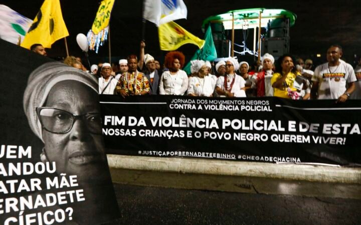 Manifestantes seguram faixa e um cartaz com retrato de Mãe Bernadete durante ato em São Paulo.