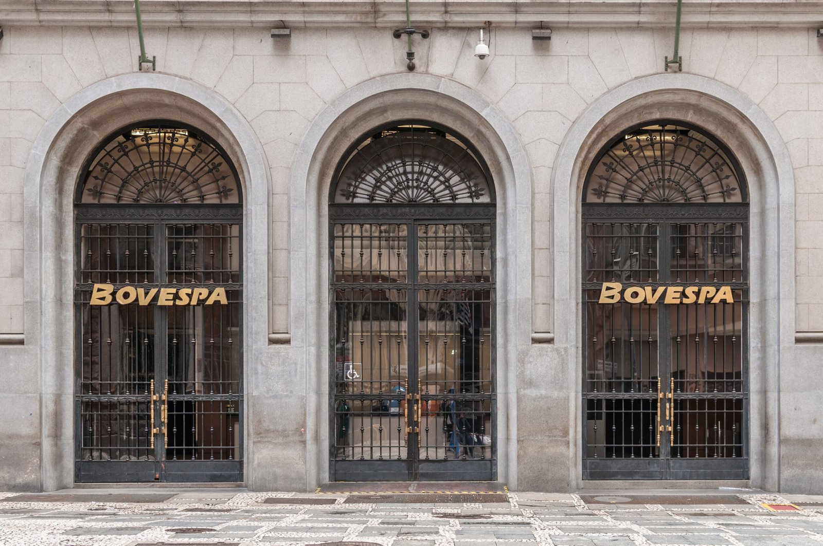 Portas em arco e letreiros da Bovespa na fachada da bolsa em São Paulo.