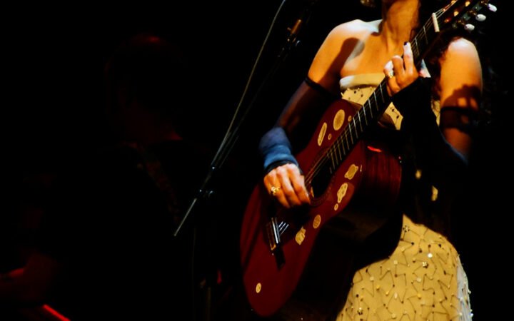 Marisa Monte canta e toca violão em show de 6 de julho de 2012; fotografia de arquivo, não da apresentação beneficente de 2026.