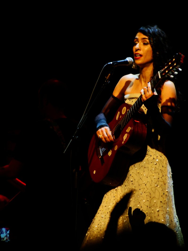 Marisa Monte canta e toca violão em show de 6 de julho de 2012; fotografia de arquivo, não da apresentação beneficente de 2026.