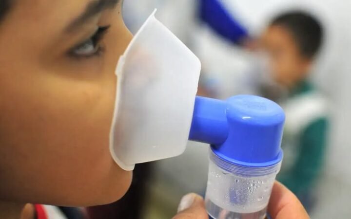 Pessoa usa máscara de nebulização em fotografia de arquivo sobre atendimento respiratório.