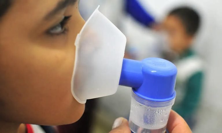 Pessoa usa máscara de nebulização em fotografia de arquivo sobre atendimento respiratório.