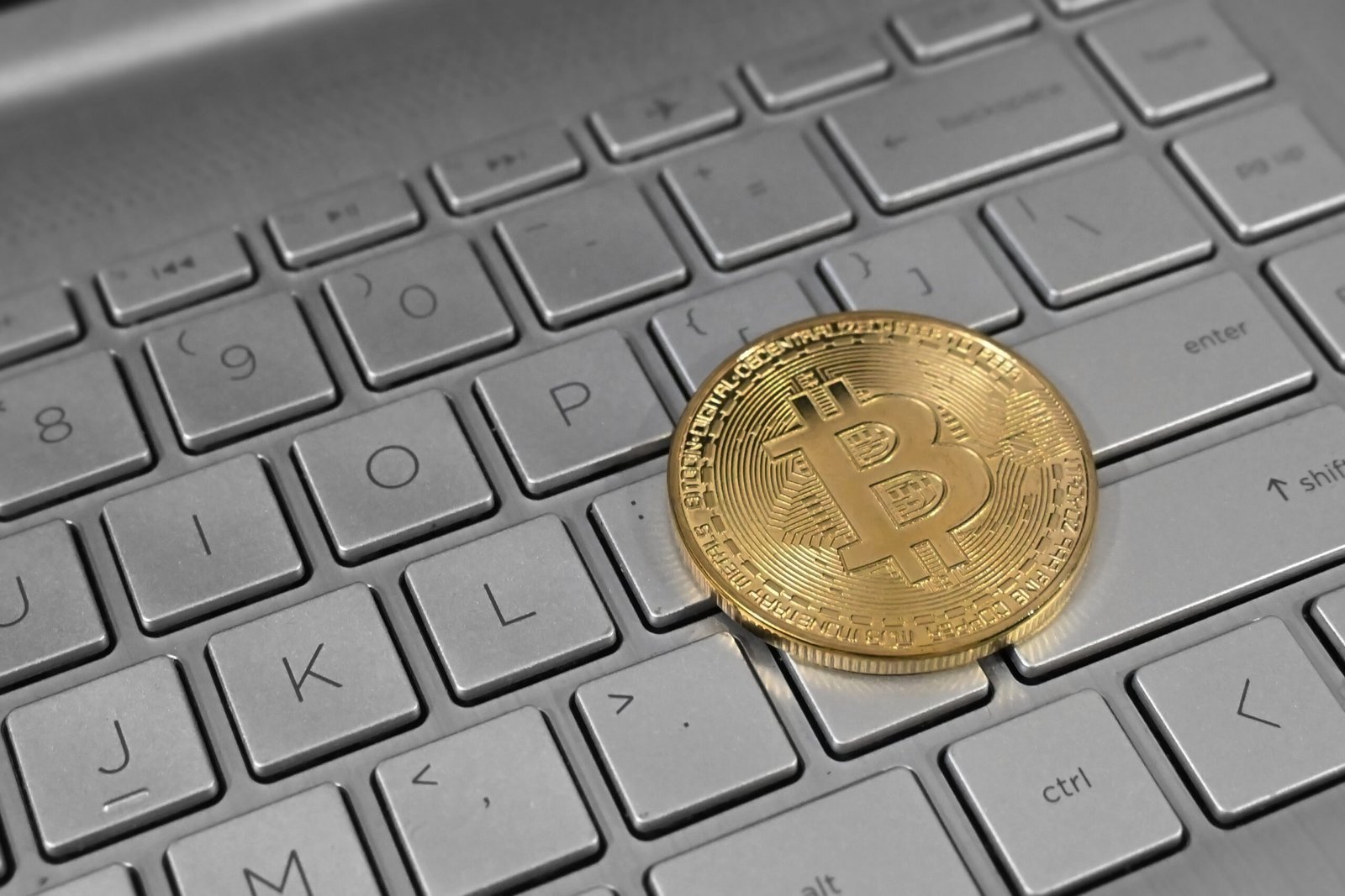 Representação física de bitcoin sobre o teclado de um computador, em fotografia de arquivo.