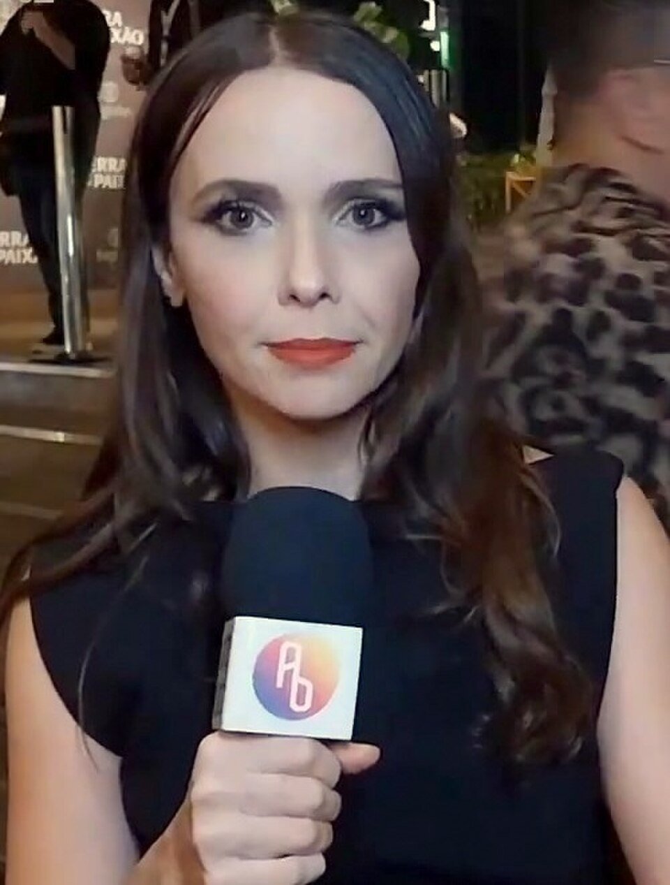Débora Falabella segura microfone durante uma entrevista de arquivo.