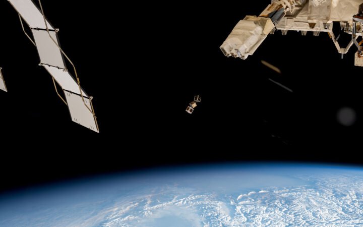 Pequenos satélites vistos da estação espacial sobre a Terra.