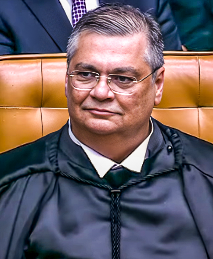 Flávio Dino de toga e óculos, sentado no plenário do STF em registro de sua posse.