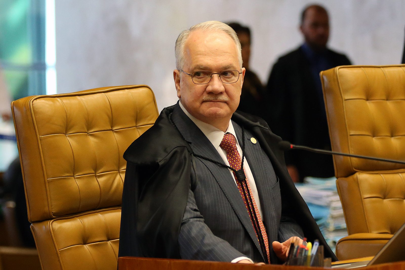 Edson Fachin de toga e óculos, sentado em cadeira do plenário do Supremo Tribunal Federal, em 2018.
