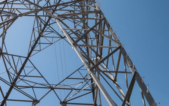 Estrutura metálica de uma torre de transmissão vista de baixo, em fotografia do NREL de 2018; não retrata obra do leilão de 2026.