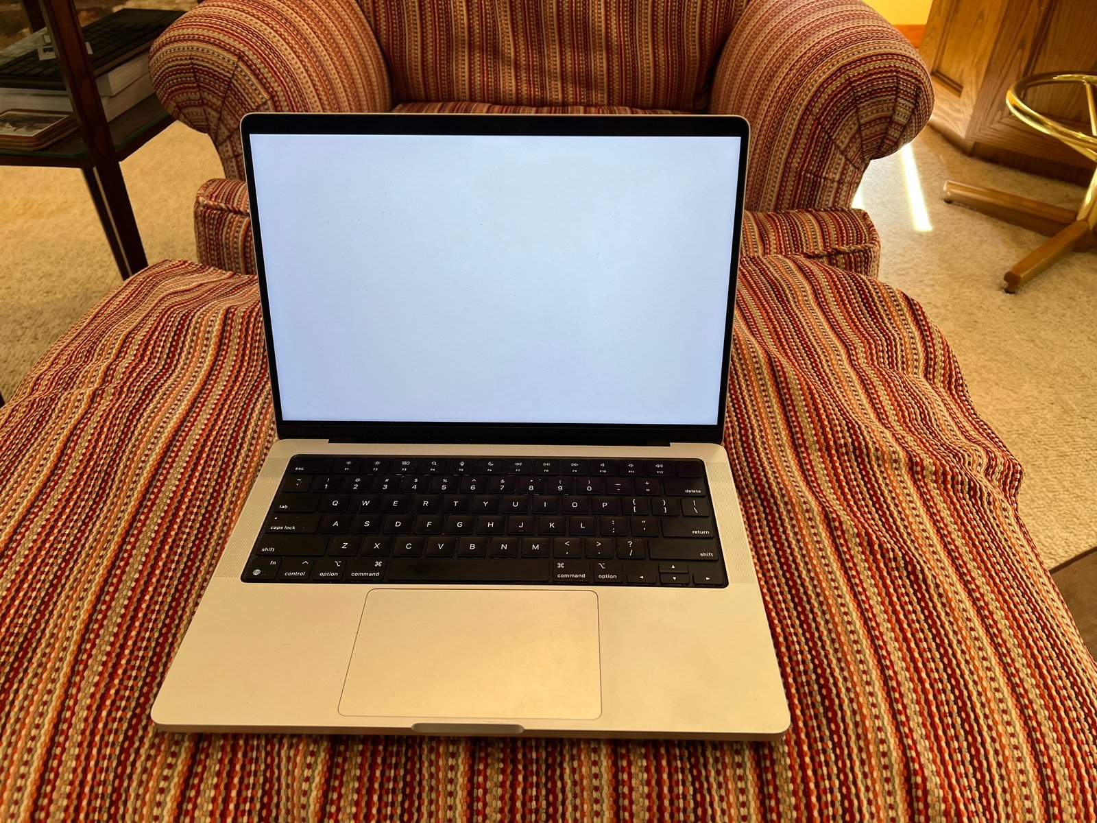MacBook Pro de 14 polegadas da geração de 2021 aberto sobre uma poltrona, em foto de arquivo de 2022.
