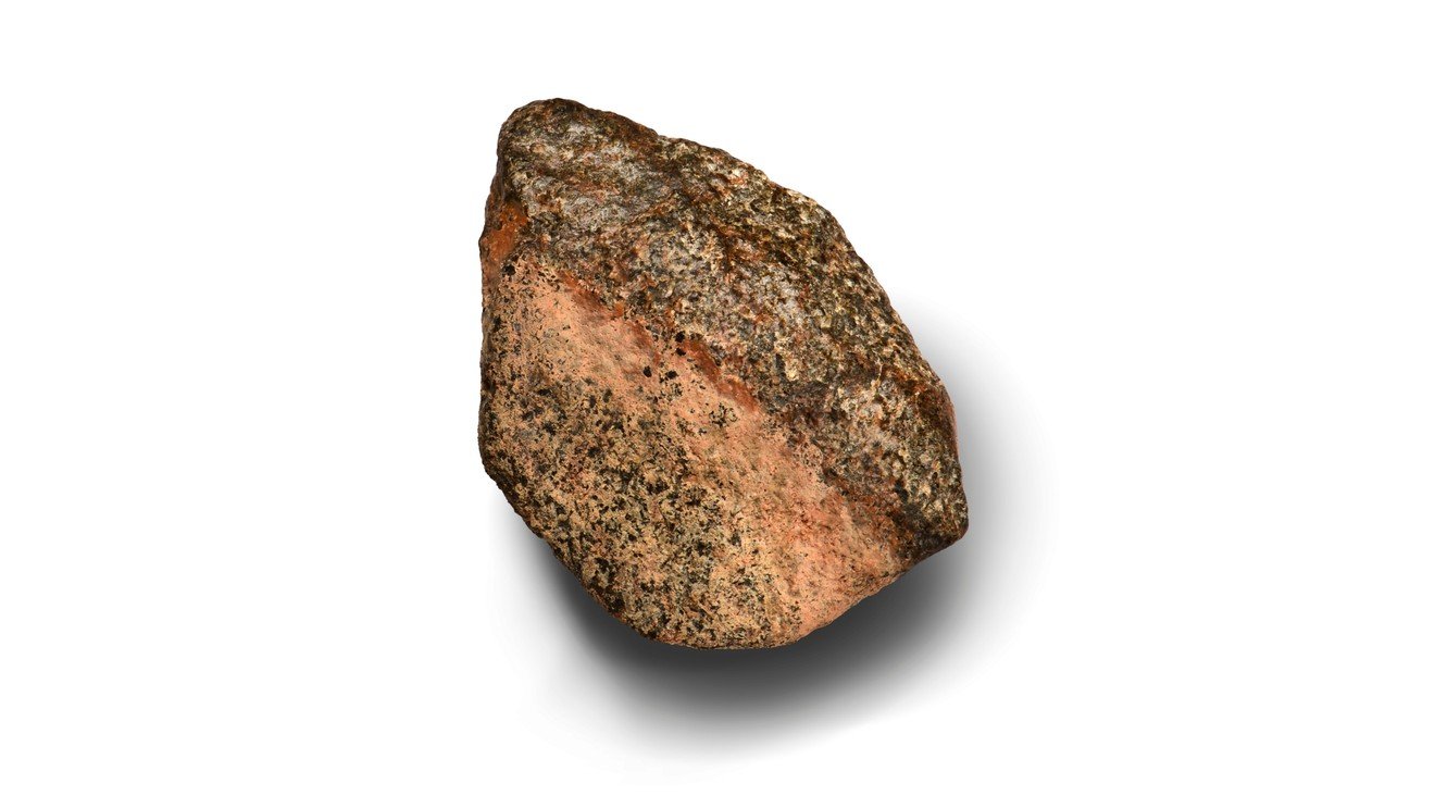 Meteorito Teghaza 001, de superfície rosada e minerais escuros, em foto de divulgação do estudo de 29 de outubro de 2026.
