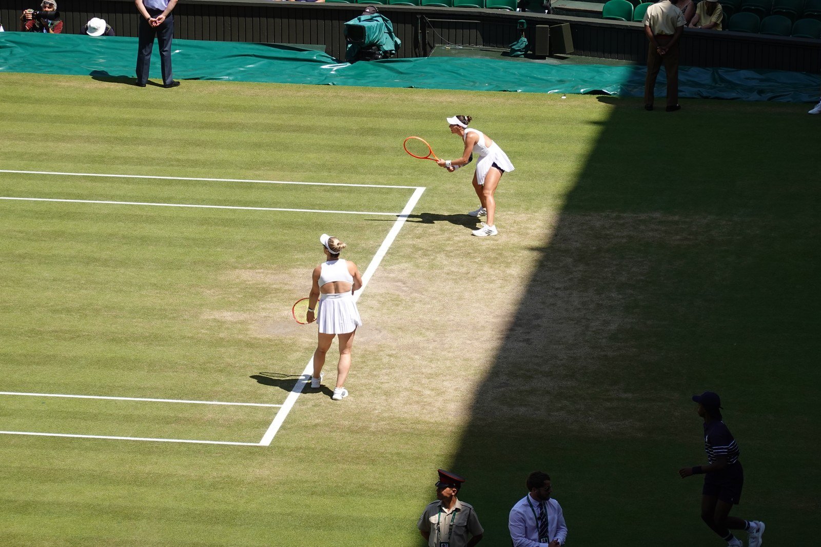 Luisa Stefani e Gabriela Dabrowski em uma quadra de grama em Wimbledon.