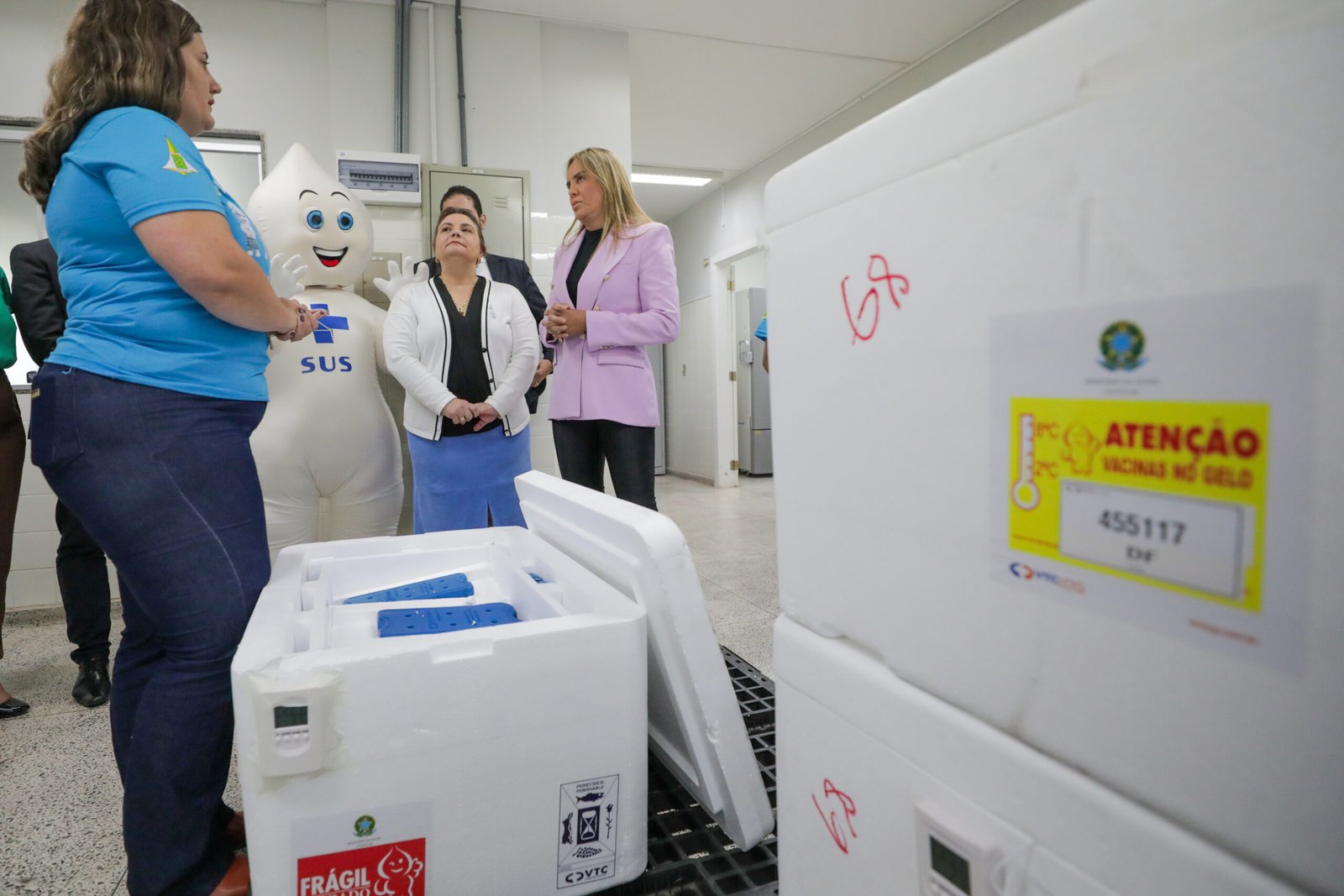 Caixas térmicas de transporte de vacinas e profissionais durante o recebimento de doses contra dengue no Distrito Federal.