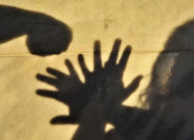 Sombras de mãos levantadas diante de um punho, em imagem ilustrativa sobre violência contra mulheres