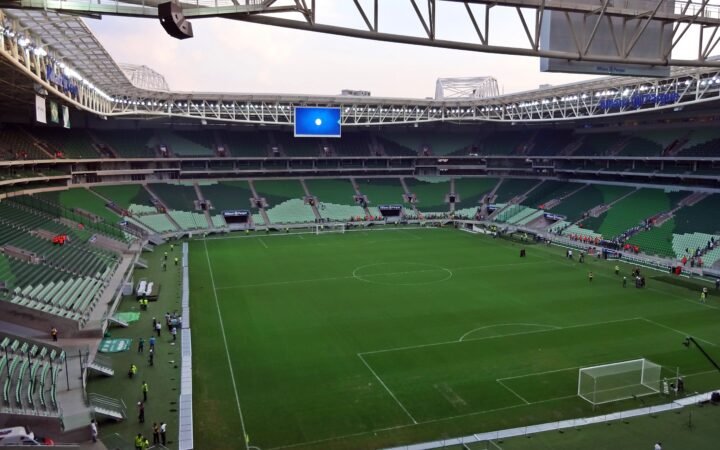 Vista interna da arena do Palmeiras, com gramado e arquibancadas verdes, em 2015