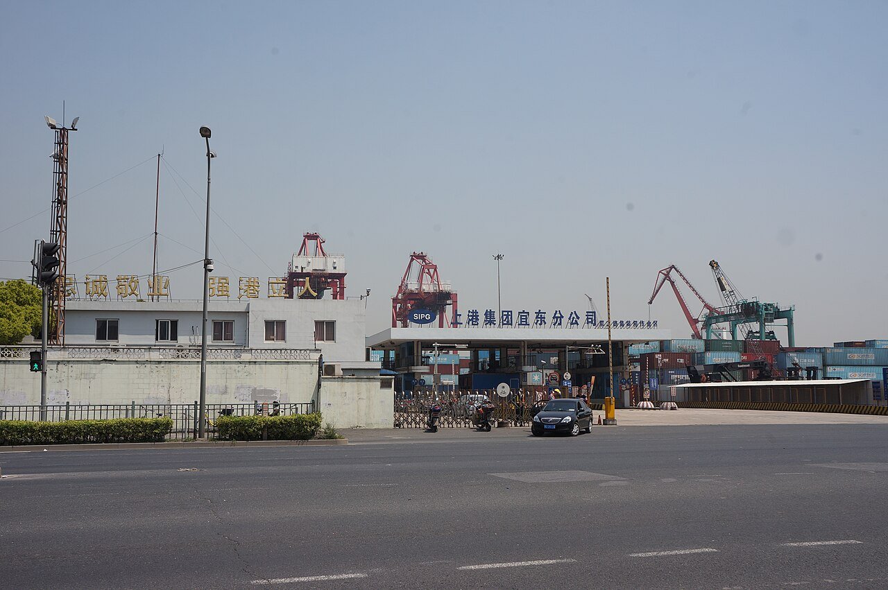 Entrada do terminal portuário de Jungong Road, em Xangai, com guindastes ao fundo