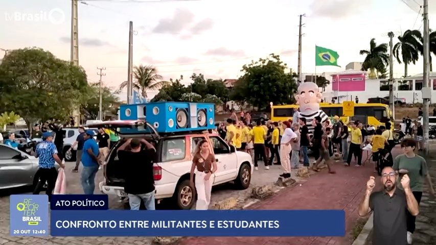 Manifestantes com camisetas amarelas, carro de som e boneco inflável durante ato na UFRN